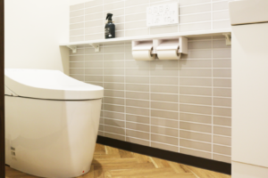 【after】ヘリンボーンの床×タイル柄のクロスでアクセント。清潔感あふれるトイレへ